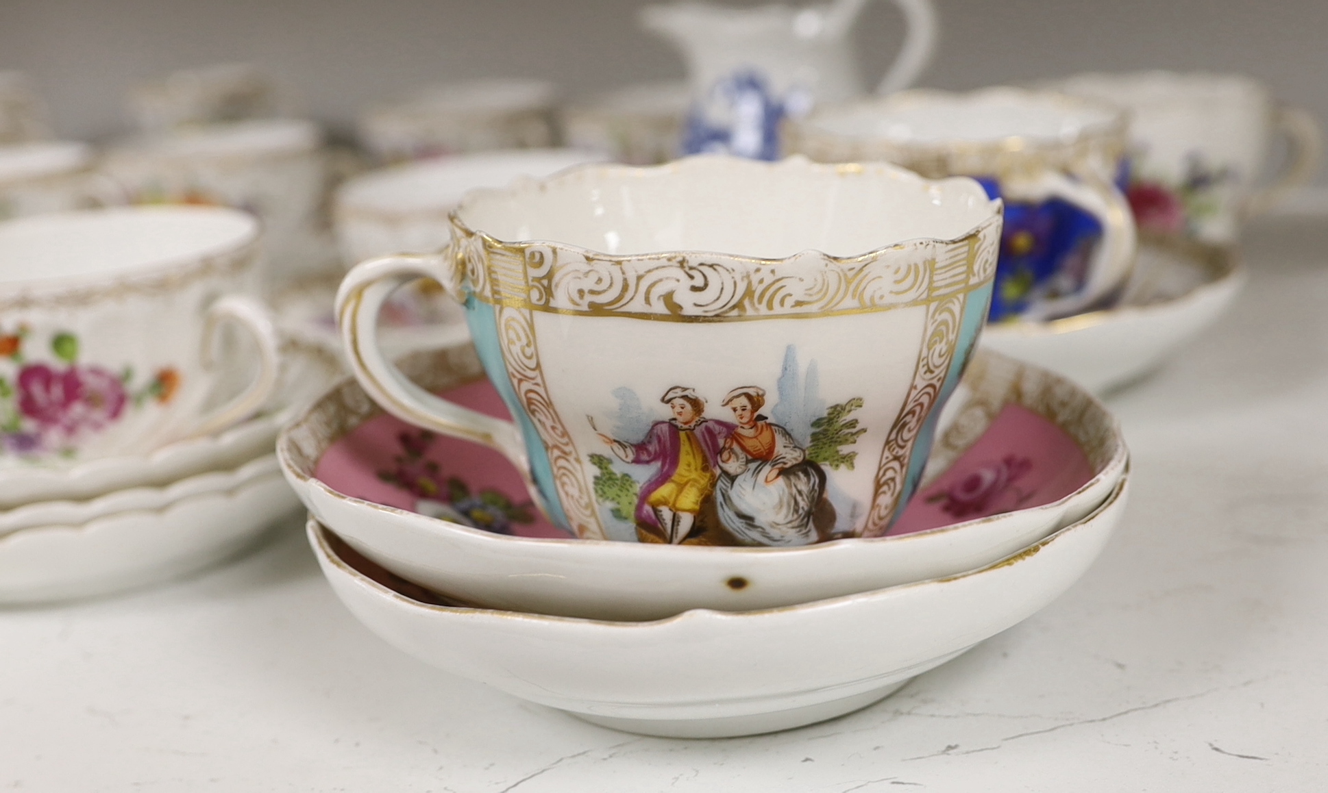 A group of porcelain Dresden tableware including cups and saucers and a blue and white jug